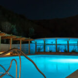Night swimming pool and Health Services pool alit in blue.