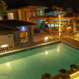 A night photos shows the pools lit up.