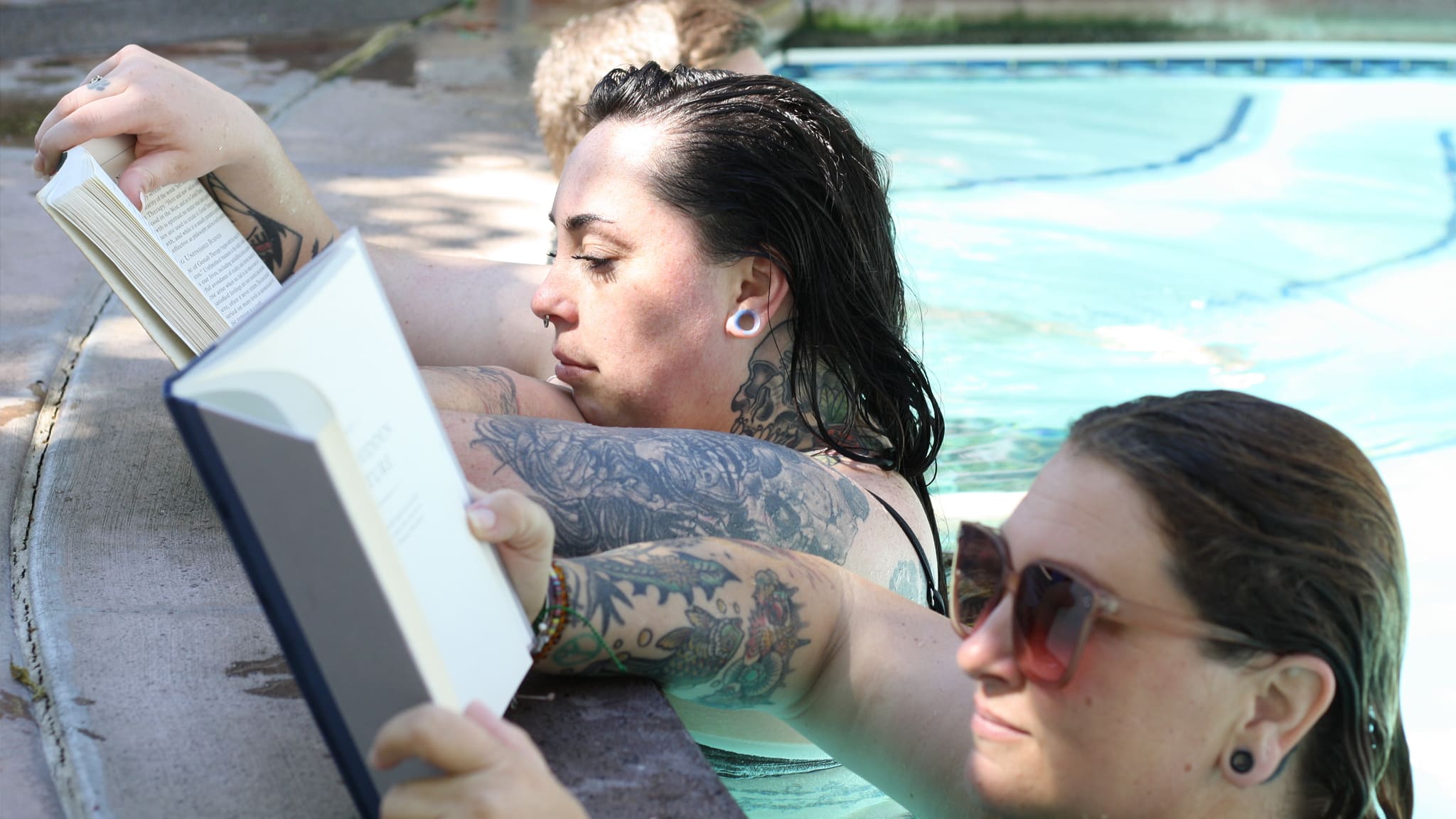Two people reading books while soaking.